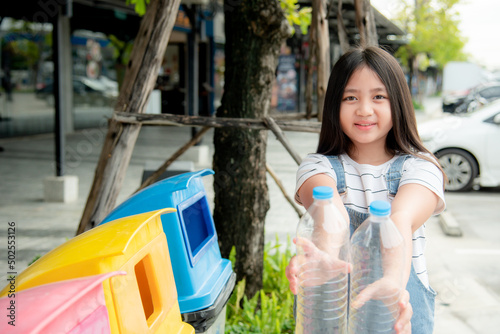 A cute girl is preparing plastic bottles to throw in the recycling bin. © Recycle Man