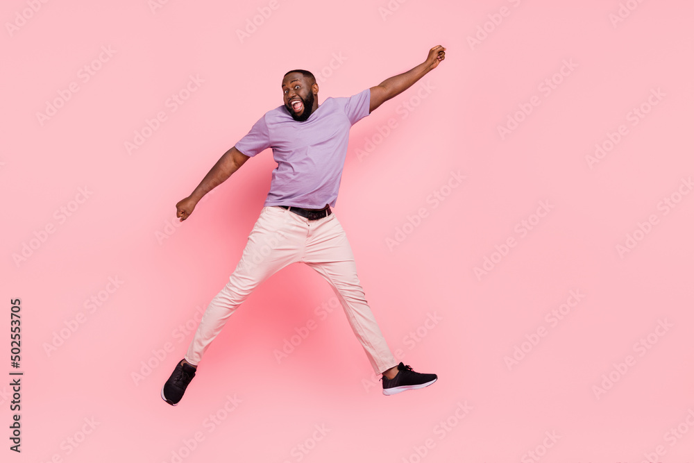 Full length body size view of attractive cheerful crazy guy jumping having fun isolated over pink pastel color background
