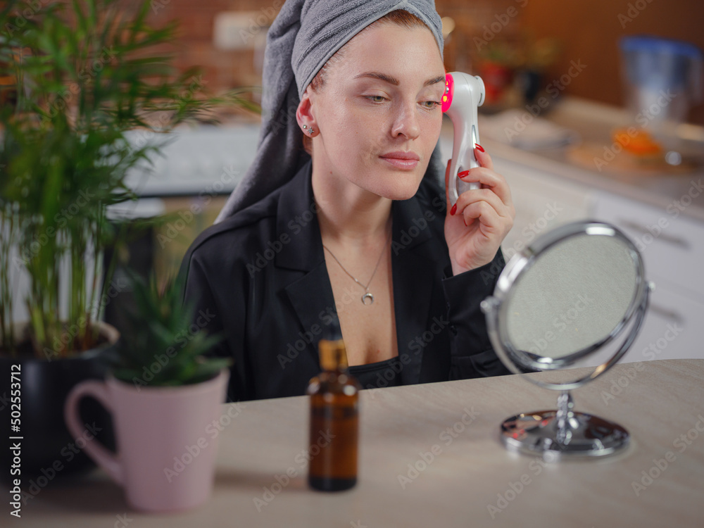 Young woman use Ultrasonic Skin Scrubber Exfoliating Wand. Skin care and age cosmetics concept. Washing and massage Face, applying spa procedures, Female facial skin care, clean the pores of dirt Young woman use Ultrasonic Skin Scrubber Exfoliating Wand. Skin care and age cosmetics concept. Washing and massage Face, applying spa procedures, Female facial skin care, clean the pores of dirt