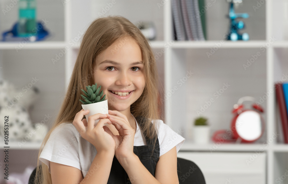 glad child hold potted plant in school classroom glad child hold potted plant in school classroom