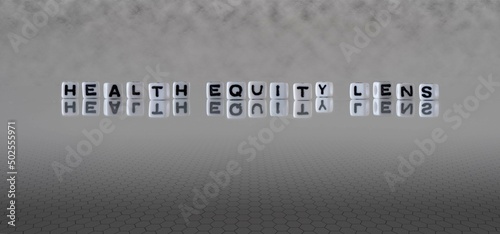 health equity lens word or concept represented by black and white letter cubes on a grey horizon background stretching to infinity