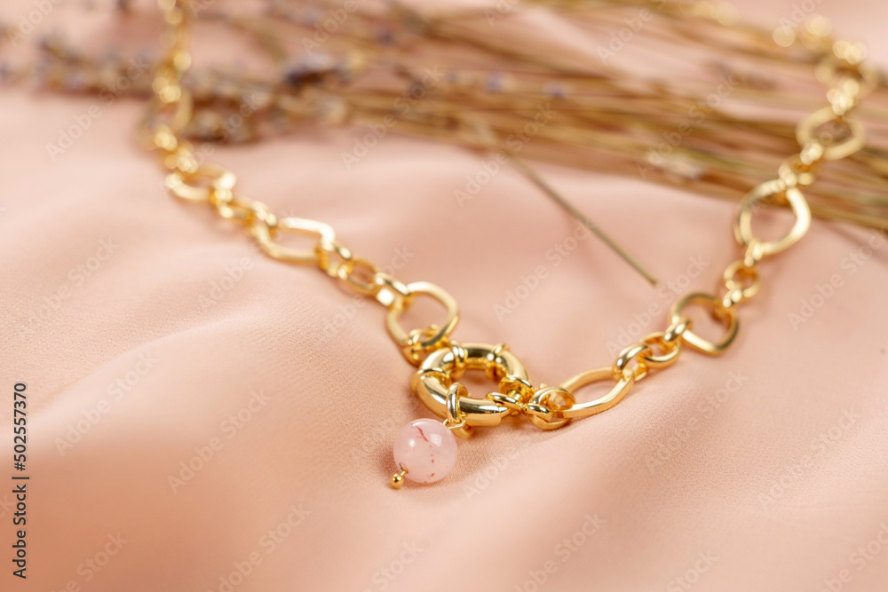 Made of rose quartz stone with a gold chain and lock. Made of rose quartz stone with a gold chain and lock.