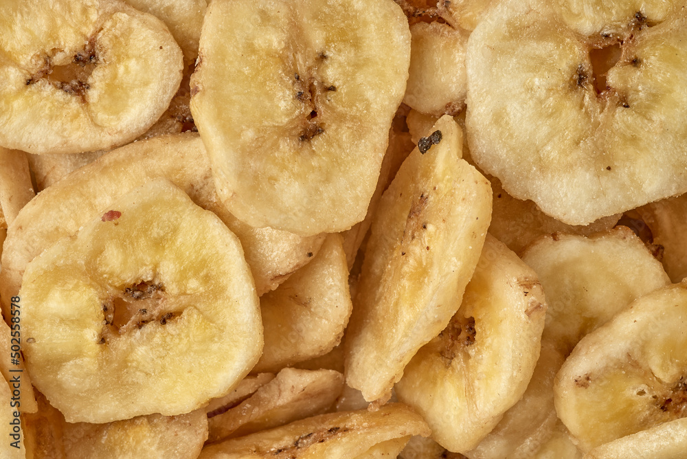 Banana chips background top view. Dried banana slices texture. Heap of dried bananas. Banana chips background top view. Dried banana slices texture. Heap of dried bananas.