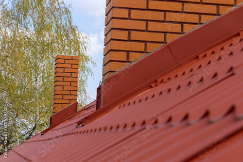 Roof housetop with red roofing metal tiles for roofers