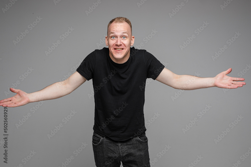handsome man with short fair hair spread his hands to the sides and doesn't know what to do handsome man with short fair hair spread his hands to the sides and doesn't know what to do