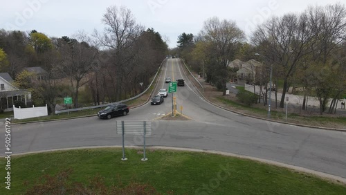 Static drone clip of traffic navigating a rotary and some offshoot roadways. View up a long hill. Cloudy. photo