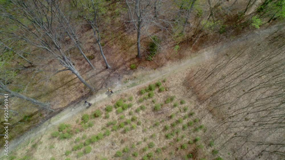 Aerial bird's eye view of forest during dry season with locals passing by through the forest on a narrow pathway on a bright sunny day. Aerial bird's eye view of forest during dry season with locals passing by through the forest on a narrow pathway on a bright sunny day.