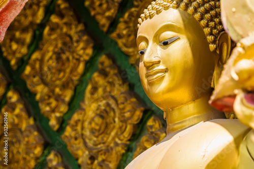 Nakhon Nayok, Thailand - April, 24, 2022 : Standing golden Buddha statue of Maniwong Temple at Nakhon Nayok, Thailand.