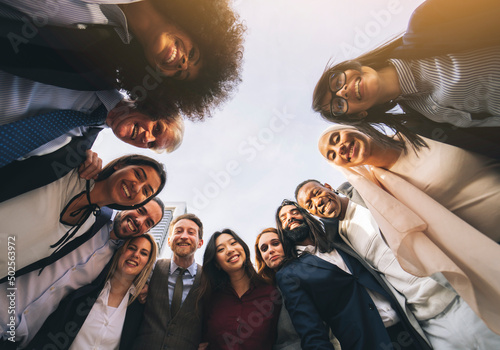 bottom view. diverse multiracial coworkers of different ages standing in a circle at sunset - business people concept -