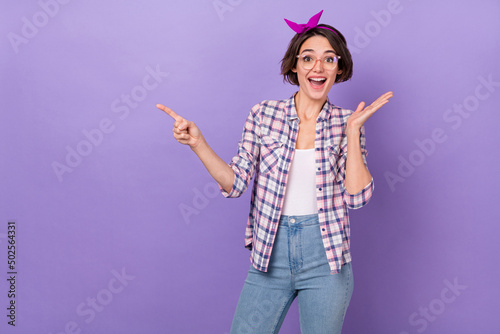 Photo of young girl excited indicate finger empty space way select promo advertise isolated over purple color background