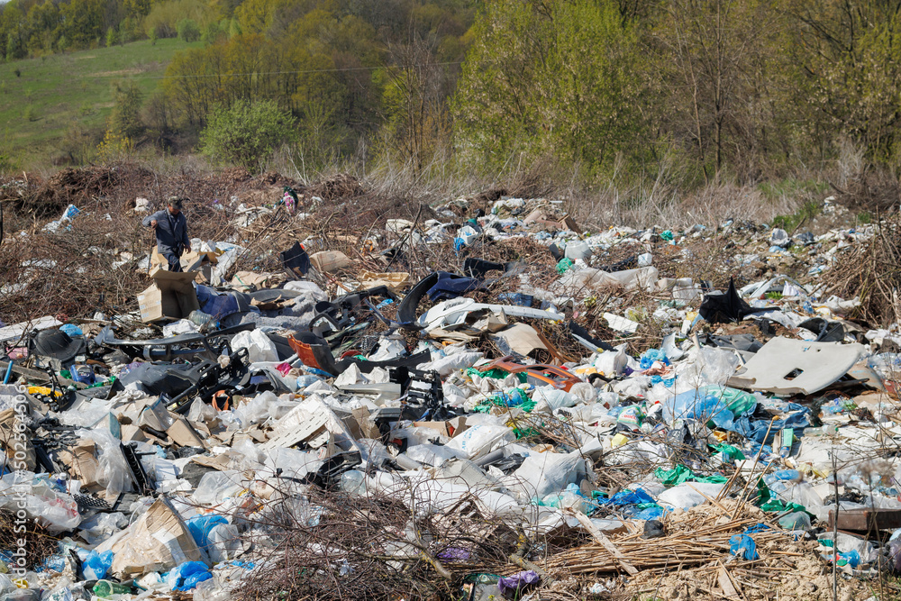 A view of the landfill. Garbage dump. A pile of plastic rubbish, food waste and other rubbish. Pollution concept. A sea of garbage starts to invade and destroy a beautiful countryside scenery