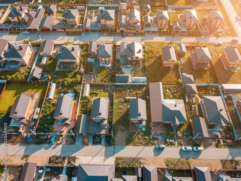 Aerial view of a luxurious village with smooth rows of two-storey duplex houses. Neighborhood in the area and real estate investments.