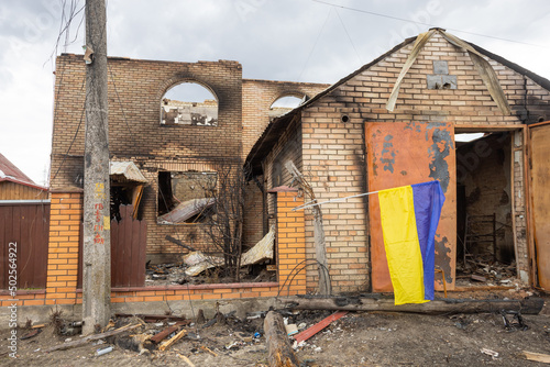 Shelled house with Ukrainian flag.