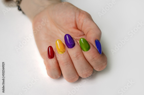 Beautiful female hand with manicure. Extended nails with stained glass gel of different colors