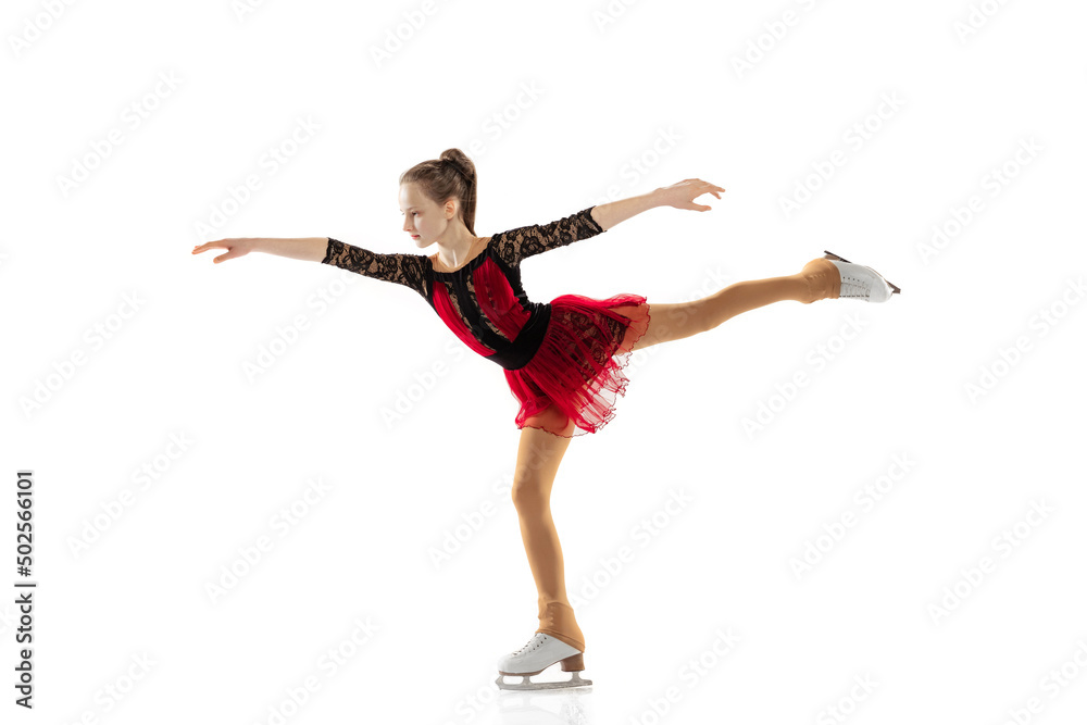 Portrait of little flexible girl, figure skating wearing stage attire posing isolated on white studio backgound. Concept of movement, sport, beauty.