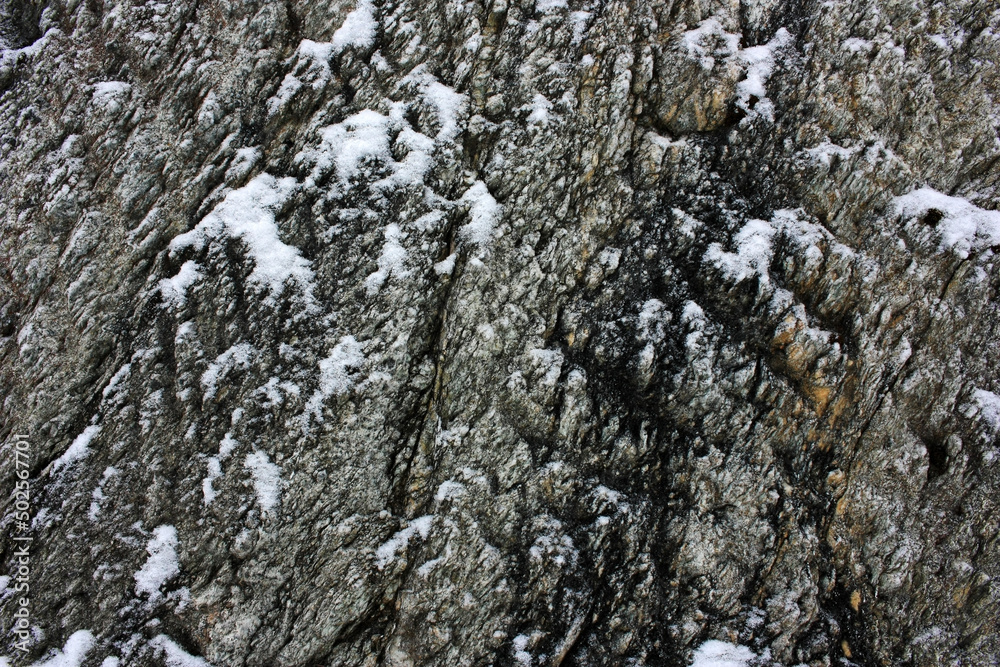 White snow on a gray rock stone White snow on a gray rock stone