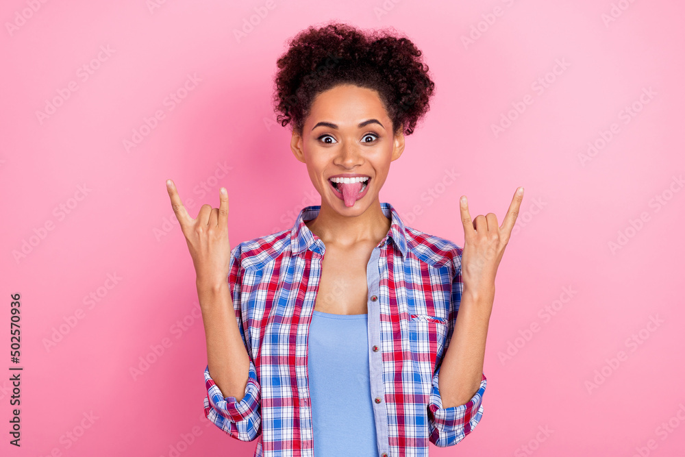 Photo of hooray brunette lady show rock sign tongue out wear red shirt isolated on pink color background Photo of hooray brunette lady show rock sign tongue out wear red shirt isolated on pink color background