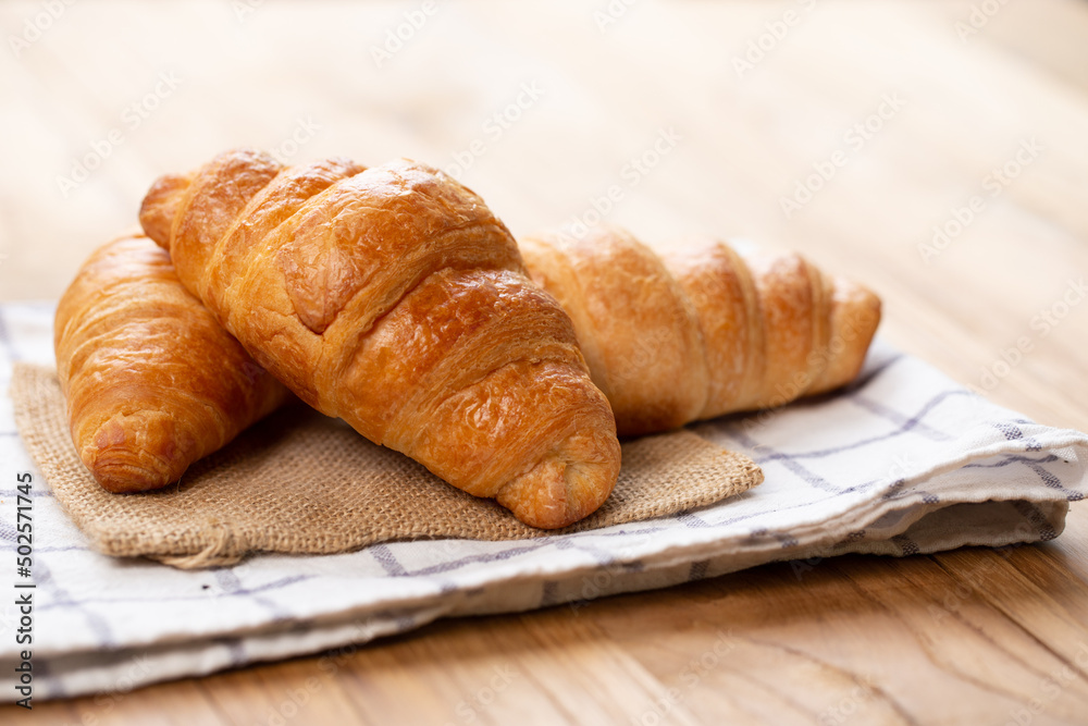 Two croissants are on plate. Croissant is a buttery, flaky, French pastry. This bread uses the French yeast-leavened laminated dough. Crispy and yummy. Two croissants are on plate. Croissant is a buttery, flaky, French pastry. This bread uses the French yeast-leavened laminated dough. Crispy and yummy.