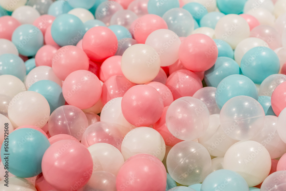Smal plastic balls for indoor ball pit children kids playground. White blue pink colored background