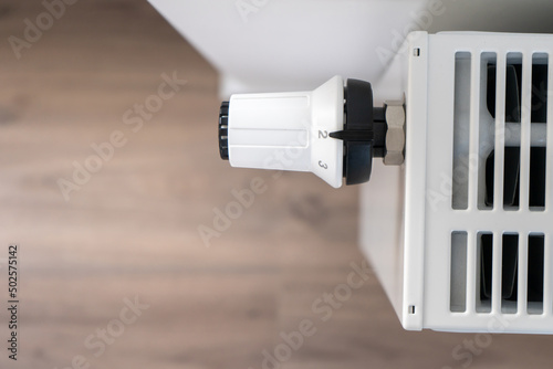 The white thermostat for adjusting the central heating radiator is set to the economical minimum temperature mode