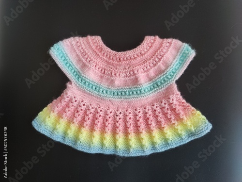 Colorful knitted dress for children. Baby clothes. Rainbow cute kid's jersey. Fashion for kids. Ideas for handmade