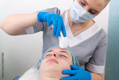 Canvas Print Young woman receiving electric galvanic anti-aging face spa massage at beauty salon