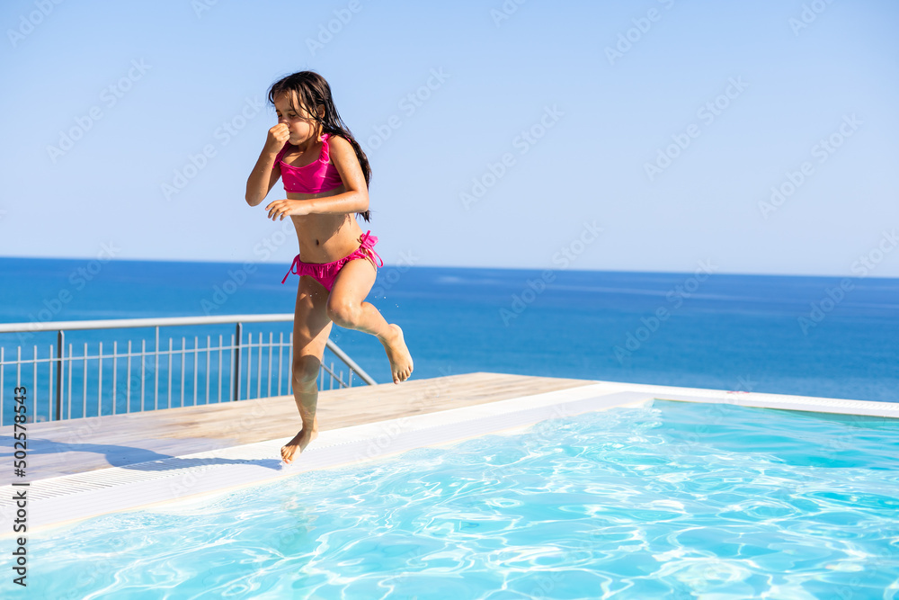 Funny little girl have a fun with a splash near swimming pool Funny little girl have a fun with a splash near swimming pool