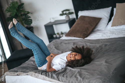 Slika na platnu A cute curly-haired girl having fun and looking enjoyed