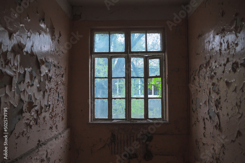 Abandoned building. A beautiful and scary corridor with shabby walls. Interior of an old abandoned building. Light from the window