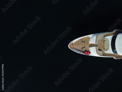 Aerial - Top down view of catching luxury motor boat racing on the water Large luxury yacht floats in the sea port on a background of blue water top view aerial view on sunset. Travel Summer Vacation