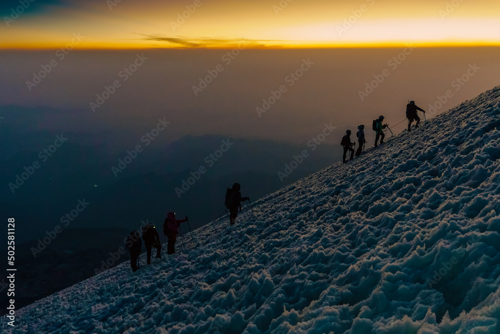 silhouettes of mountaineers at sunrise