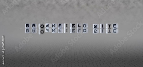 brownfield site word or concept represented by black and white letter cubes on a grey horizon background stretching to infinity photo