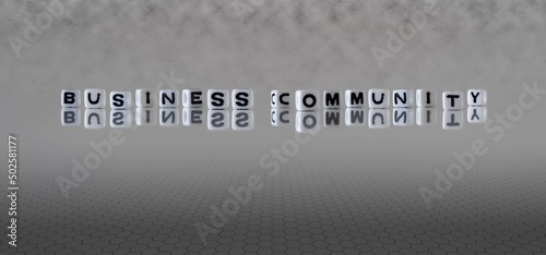 business community word or concept represented by black and white letter cubes on a grey horizon background stretching to infinity