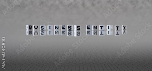 business entity word or concept represented by black and white letter cubes on a grey horizon background stretching to infinity photo