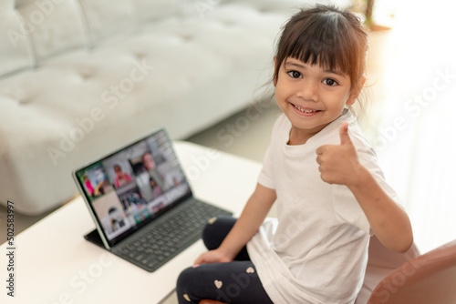 Asian little girl taking class on line and happy for Homeschool Quarantine coranavirus pandemic concept photo