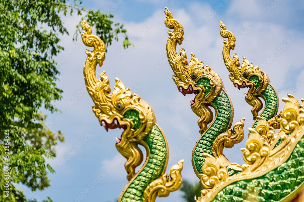 carving naga on the roof of temple with blue sky