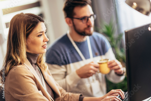 Young couple working on a project while sitting at the desk at home