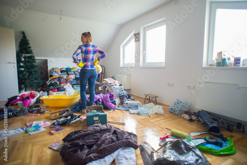 Young angry woman preparing to clean mess in the attic 