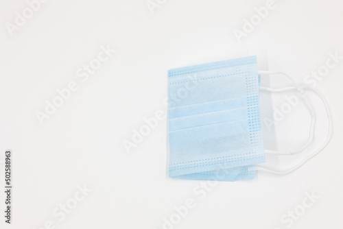 disposable blue new medical mask folded in half isolated on a white background
