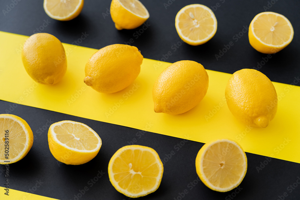 Flat lay of organic lemons on black and yellow background