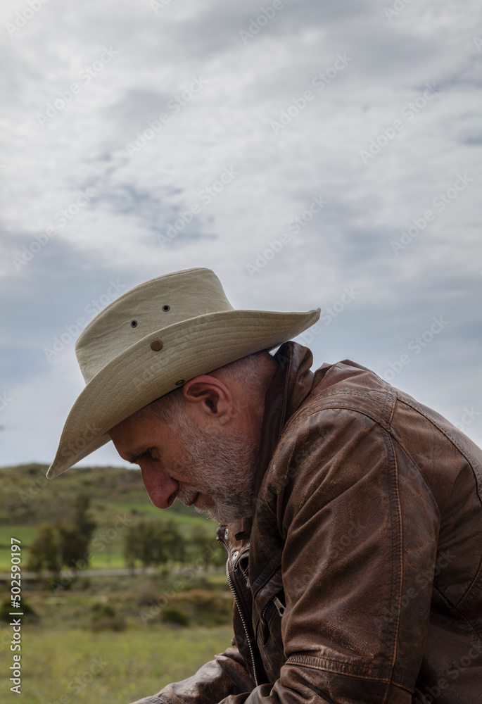 Portrait of adult man in cowboy hat on field