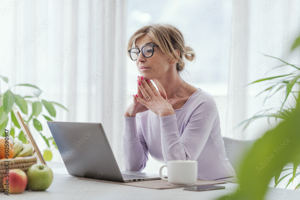 Mature woman using her laptop at home Mature woman using her laptop at home
