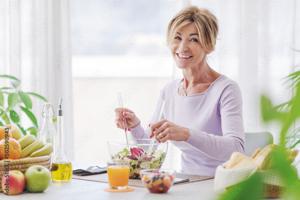 Happy mature woman having lunch break