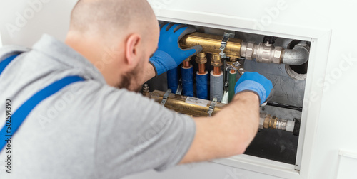 Professional plumber installing plumbing manifolds