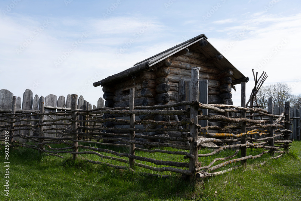 old wooden building surrounded by branch fence old wooden building surrounded by branch fence