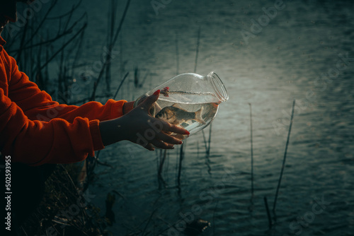 Women's hands hold a balloon with river fish