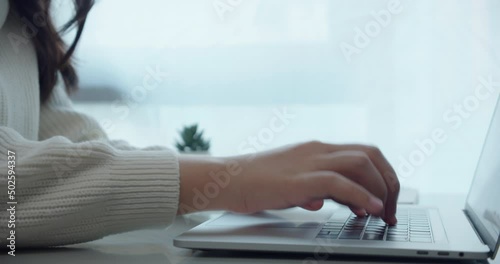 Close up of  young business women hand using typing on laptop notebook keyboard on the desk at home.Busy working on laptop keyboard for send job or emails.Female surf on a web browser online.