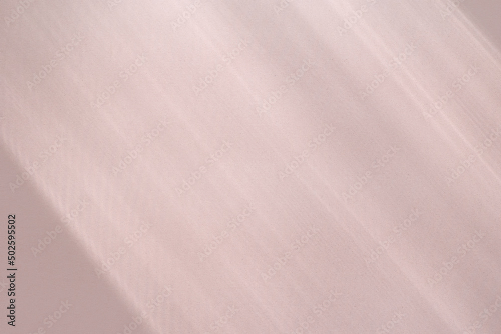 Top view flat lay background with organic shadows, bokeh, and texture on a pink colored kraft paper background. Minimal summer lights and shadow concept. Top view flat lay background with organic shadows, bokeh, and texture on a pink colored kraft paper background. Minimal summer lights and shadow concept.