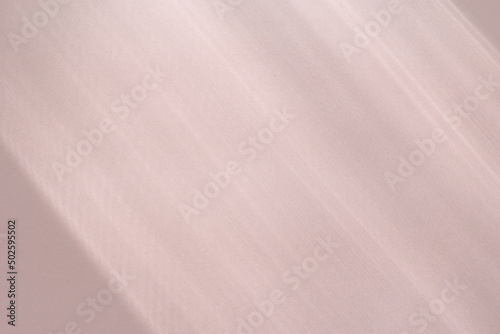 Top view flat lay background with organic shadows, bokeh, and texture on a pink colored kraft paper background. Minimal summer lights and shadow concept.