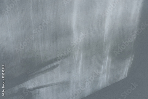 Top view flat lay background with organic shadows, bokeh, and texture on a blue gray colored kraft paper background. Minimal summer lights and shadow concept.